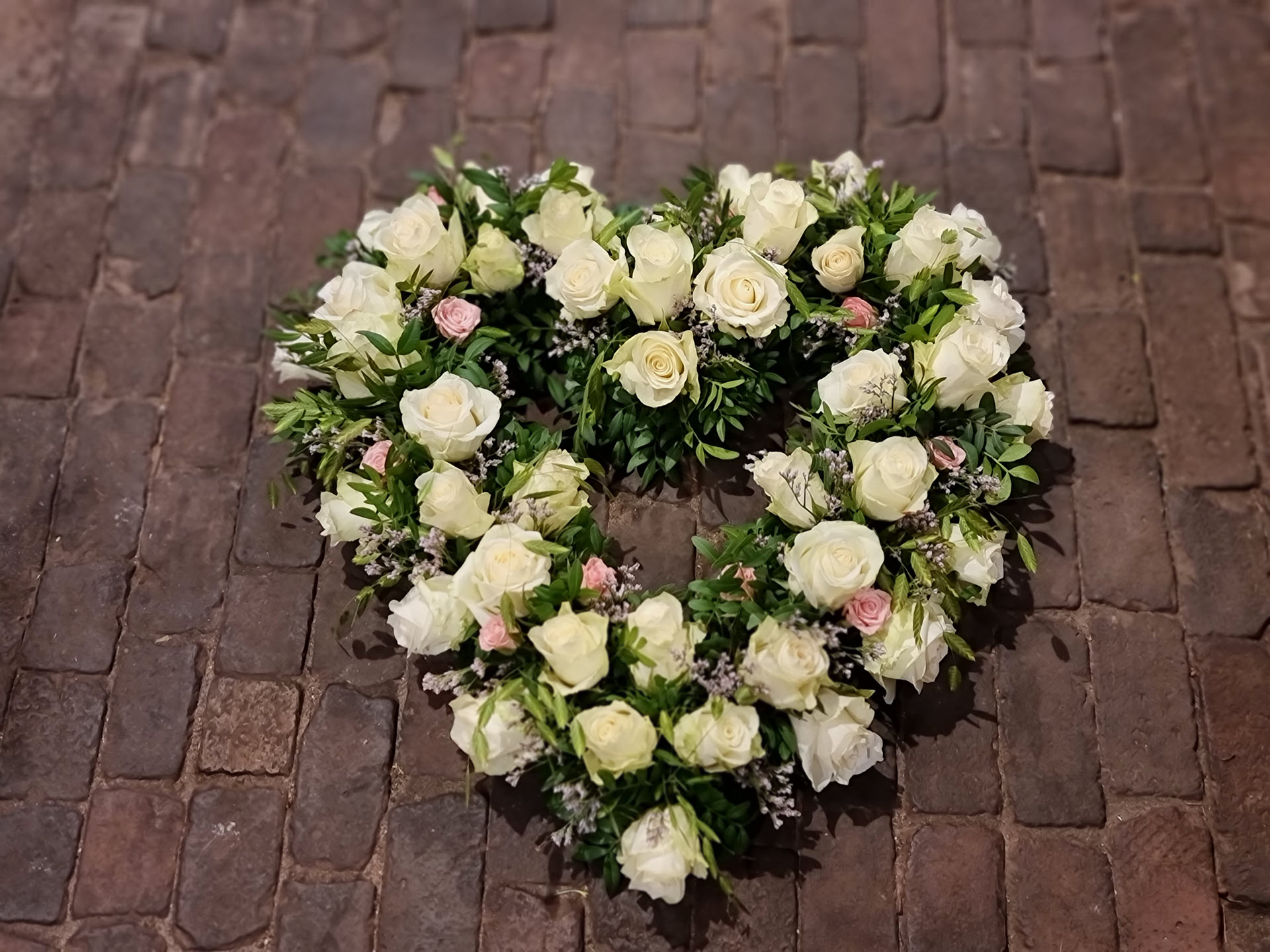 Bloemsierkunst Groeneveld bloemen uitvaart hartvorm open met witte rozen