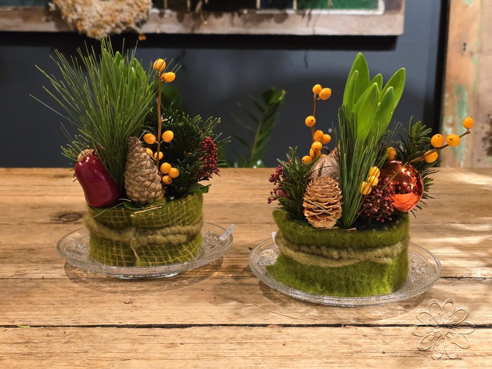 Kerst bij Bloemsierkunst Groeneveld. Adembenemend als je binnen stapt in onze winkel vol geurige dennen en sprankelende kerststukken. Maak ook jouw kerstdagen extra bijzonder met een amaryllis kersboeket of een sfeervolle kerstkrans.